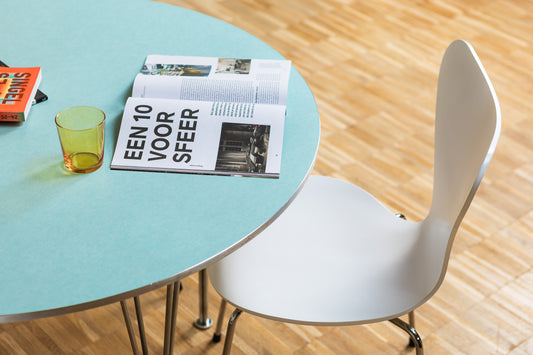 Supercircular table in blue-green by Hein-Mathsson with butterfly chairs by Jacobsen - Fritz Hansen